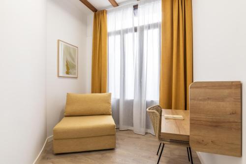 a room with a chair and a desk and a window at Moontels Plaza de Vannes in Valencia