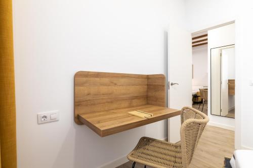 a room with a wooden shelf on the wall with a chair at Moontels Plaza de Vannes in Valencia
