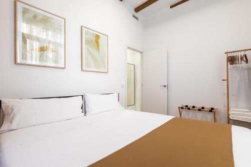 a white bedroom with a large bed with white pillows at Moontels Plaza de Vannes in Valencia