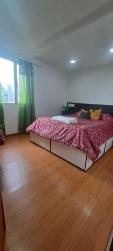 a large bed in a room with a wooden floor at Casona Los Coihues in Tolhuin