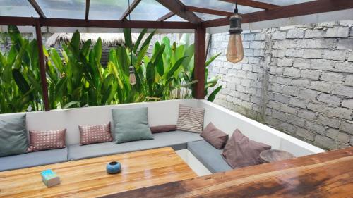 een bank op een veranda met kussens en een tafel bij Sayang House in Kuta Lombok