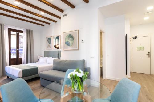 a living room with a bed and a glass table at Moontels Plaza de Vannes in Valencia