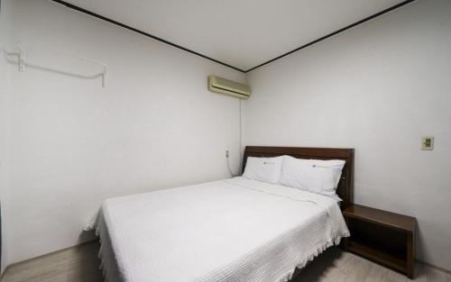 a bedroom with a large white bed in a room at Greenbeach motel 그린비치 in Geoje