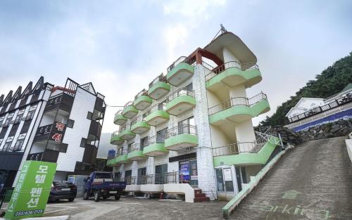 - un bâtiment avec balcon sur le côté d'une rue dans l'établissement Greenbeach motel 그린비치, à Geoje