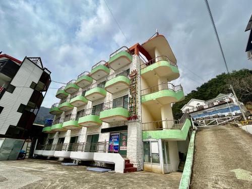 a building with colorful balconies on the side of it at Greenbeach motel 그린비치 in Geoje