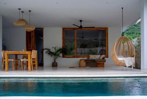 a living room with a swimming pool and a house at Marlaca Villas - Pampita - One bed Kuta Central in Kuta Lombok