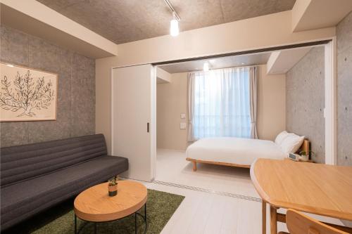 MINI HOUSE Tokyo South في طوكيو: غرفة معيشة مع أريكة وسرير