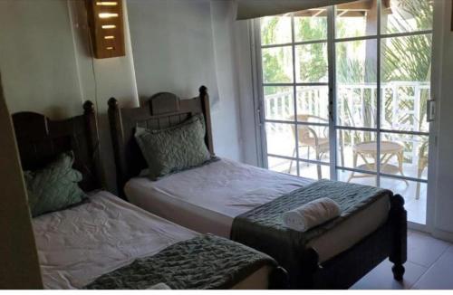 1 dormitorio con 2 camas individuales y balcón en villa Doña rosa, en Concepción de La Vega