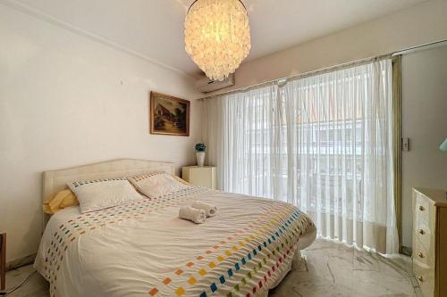 une chambre avec un grand lit et une grande fenêtre dans l'établissement IDEAL CONGRESS - 3P apartment 2 minutes walk from the Croisette, à Cannes