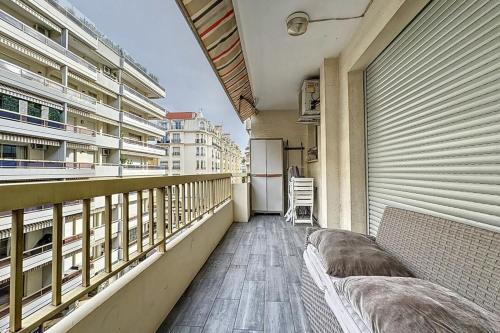 - un balcon avec un lit et un réfrigérateur dans un bâtiment dans l'établissement IDEAL CONGRESS - 3P apartment 2 minutes walk from the Croisette, à Cannes