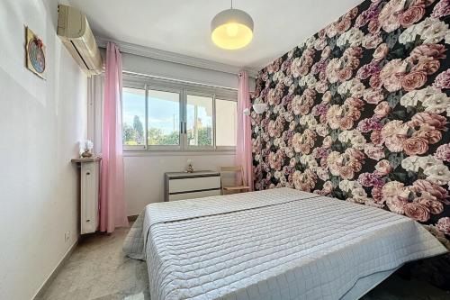 a bedroom with a bed with a floral wall at Apartment 2 room in the City Center in Le Cannet