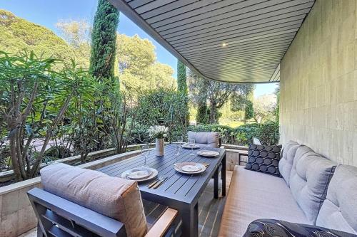 un patio con mesa de madera y sillas en Superb studio with terrace in a high-end residence with swimming pool, en Cannes