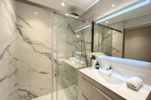 y baño con lavabo y ducha acristalada. en Superb studio with terrace in a high-end residence with swimming pool, en Cannes