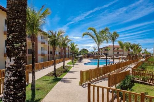a resort with a swimming pool and palm trees at Ondas Praia Resort in Porto Seguro