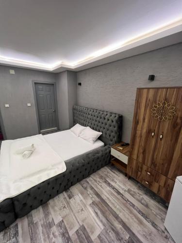 um quarto com uma cama grande e um armário de madeira em Aden em Bursa