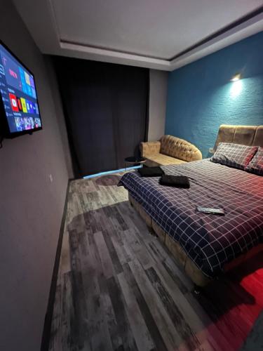 um quarto com uma cama e uma televisão de ecrã plano em Aden em Bursa