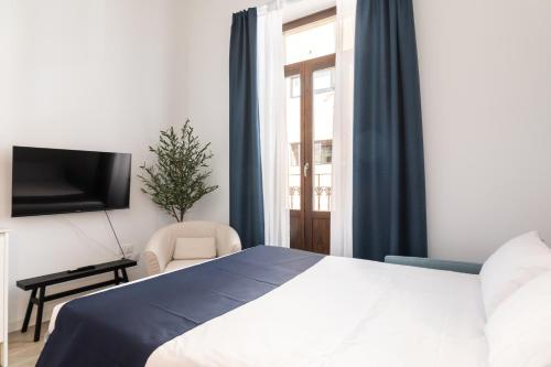 a bedroom with a bed and a tv and a window at Moontels Plaza de Vannes in Valencia