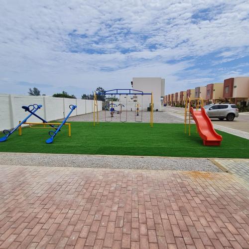 a playground with a slide and a swing at Suite con Vista al Mar, Piscinas, Jacuzzi, Wifi in Playas