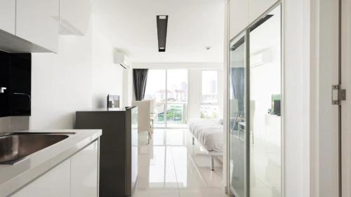 a white kitchen with a sink and a bedroom at Pattaya City Center Residence K in Pattaya Central