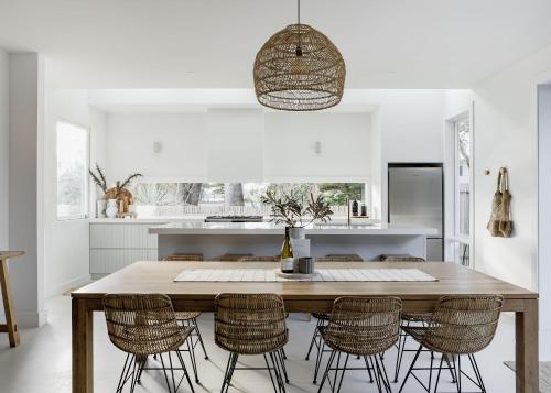 a kitchen with a wooden table and chairs at Salt at Shoal Bay in Shoal Bay