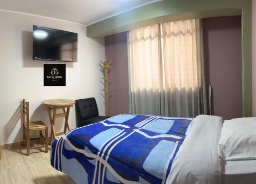 1 dormitorio con 1 cama, 1 mesa y 1 silla en HOSTAL SANTA ISABEL-JAUJA, en Jauja
