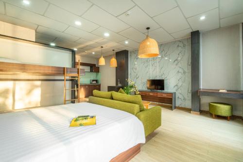 een slaapkamer met een bed, een bank en een tv bij Benzen Boutique Stays in Da Nang