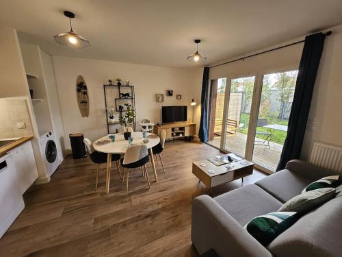 a living room with a couch and a table at Appartement élégant et bien situé in Biscarrosse