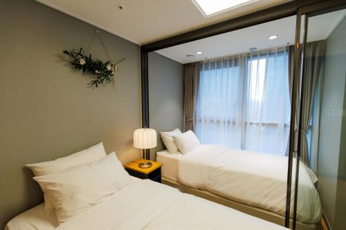 two beds in a room with a mirror at Wecostay Gangnam in Seoul