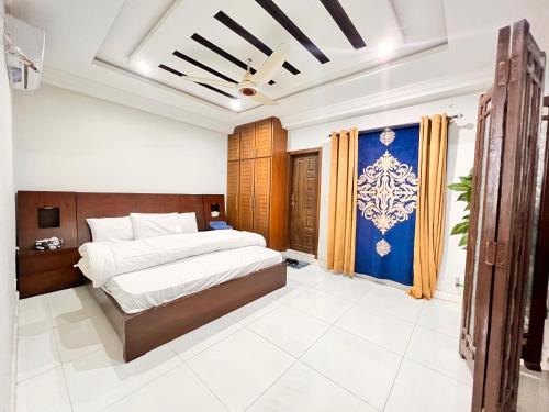 a bedroom with two beds and a blue wall at Luxury Apartment Hotel in Islamabad