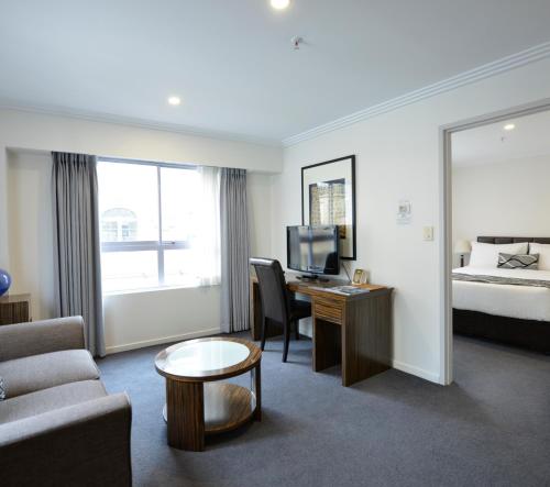 a hotel room with a bed and a desk with a computer at Darling Harbour Apartments in Sydney