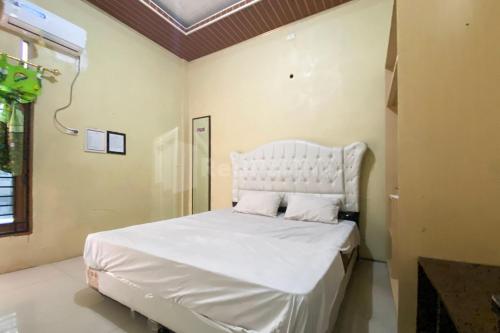 a bedroom with a large white bed with two pillows at Aisyah Homestay Syariah RedPartner in Stabat