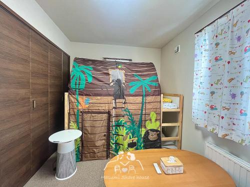 a room with a wall with a painting of a house at 札幌駅地下鉄15分直通/駐車無料/南向新築戸建/最大3名/車で最寄り駅お迎え可能/北海道大学バス直通 in Sapporo