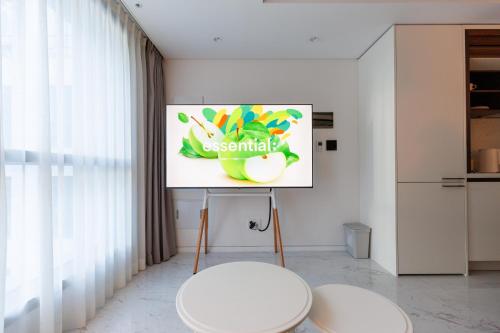 two white stools in a room with a picture on the wall at Wecostay Gangnam in Seoul