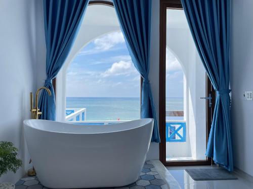 Baño con bañera grande frente a una ventana en VILLA BIỂN XANH 3 - View Biển Đảo Phú Quý, en Cu Lao Thu