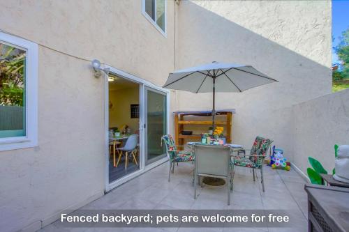 een tafel en stoelen met een parasol op een patio bij Entire Spacious 4-Bedroom House w Free Pool Access, Garage & Parking in Prime Location in San Diego