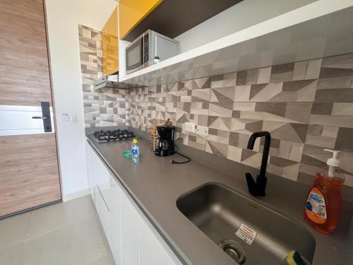 uma cozinha com um lavatório e uma bancada em Santa Marta- Pozos Colorados Ocean view Suite Bello Horizonte em Santa Marta