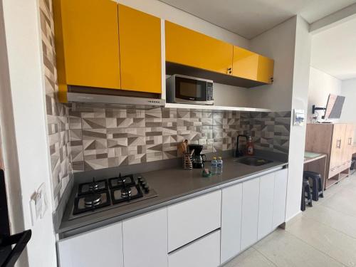 uma cozinha com armários amarelos e uma bancada em Santa Marta- Pozos Colorados Ocean view Suite Bello Horizonte em Santa Marta