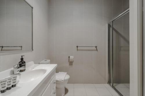 y baño con ducha, lavabo y aseo. en Cosy 1-Bed In Peaceful Location Across From Park en Canberra