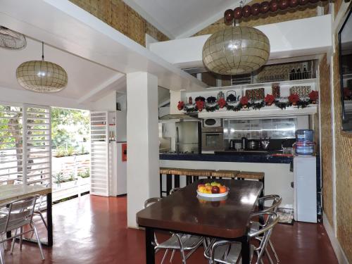 a kitchen with a table with a bowl of fruit on it at Orange Mangrove Pension House in Puerto Princesa City