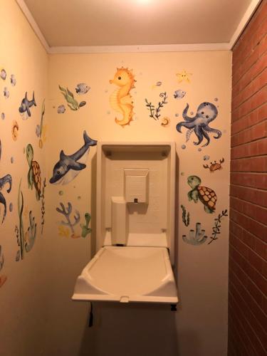 a bathroom with a toilet with stickers on the wall at Cornucopia hotel in Wallaroo