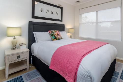 1 dormitorio con 1 cama grande con manta rosa en Charming 1-Bed Apartment Near Nature Park, en Campbell