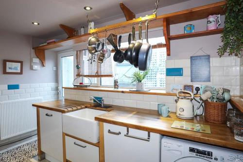 a kitchen with a sink and a counter with pots and pans at Beautiful Victorian home with private pet-friendly garden sleeps 6 in Holyhead