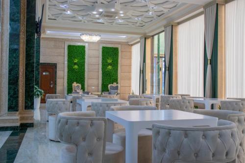a dining room with white tables and chairs at Garden Plaza Bukhara in Bukhara