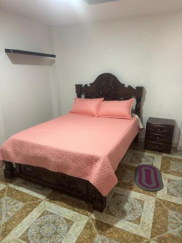 a bedroom with a bed with pink pillows on it at Apartamento La Hermosa in Santa Rosa de Cabal