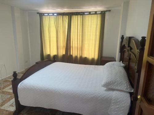 a bedroom with a white bed with a window at Apartamento La Hermosa in Santa Rosa de Cabal