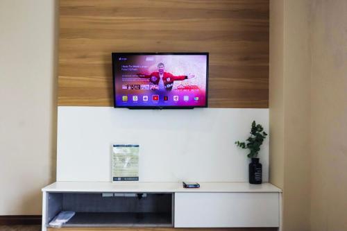 a television sitting on top of a wall at Homesuite' Home at Aeropod SOVO in Kota Kinabalu