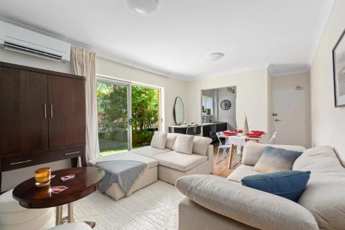 a living room with a couch and a table at Northern Beaches Garden Hideaway in Sydney