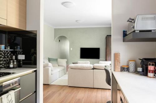 two views of a kitchen and a living room at Northern Beaches Garden Hideaway in Sydney