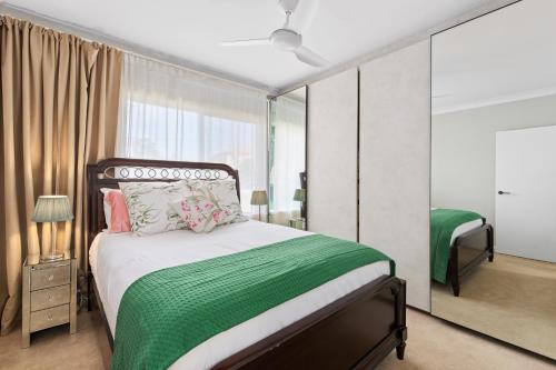 a bedroom with a bed and a large mirror at Northern Beaches Garden Hideaway in Sydney