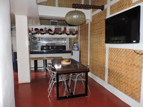 a kitchen with a table with a bowl of fruit on it at Orange Mangrove Pension House by SMS Hospitality in Puerto Princesa City